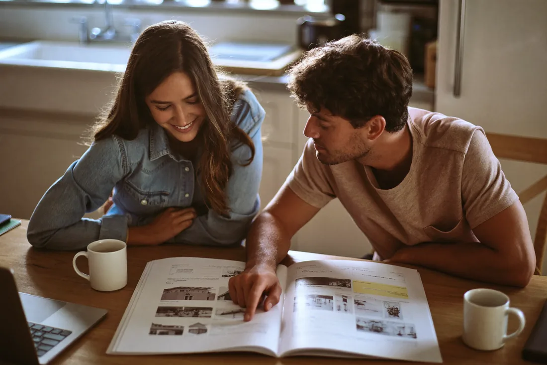 First-home buyers reviewing a building and pest inspection report at their kitchen table before deciding whether to negotiate or proceed.