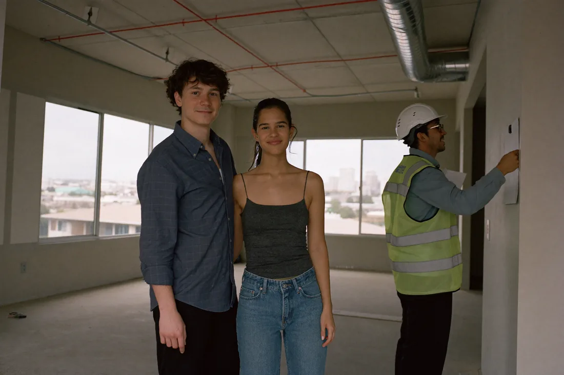 First home buyers inspecting a near-complete off-the-plan apartment with a building inspector before settlement in Australia.