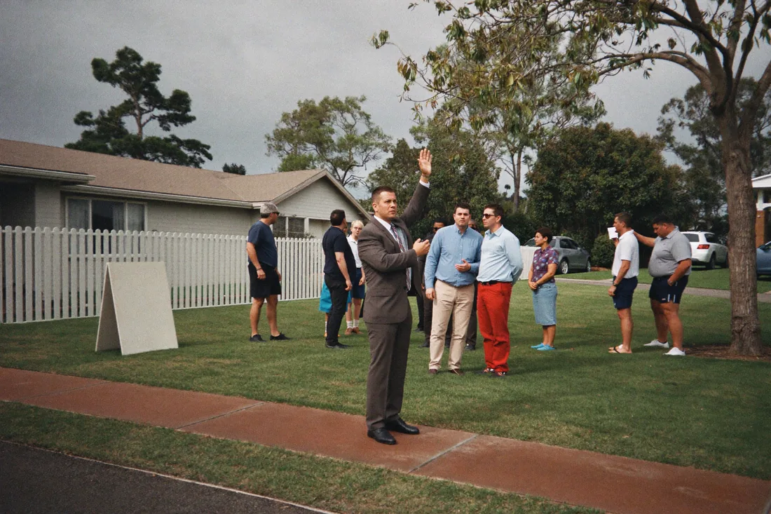 Bidders at an Australian suburban property auction, where no cooling-off period applies once the hammer falls.