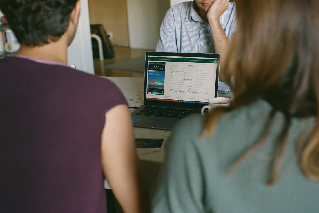 An Australian couple reviewing their home loan borrowing power with a mortgage broker, a credit card on the table between them.