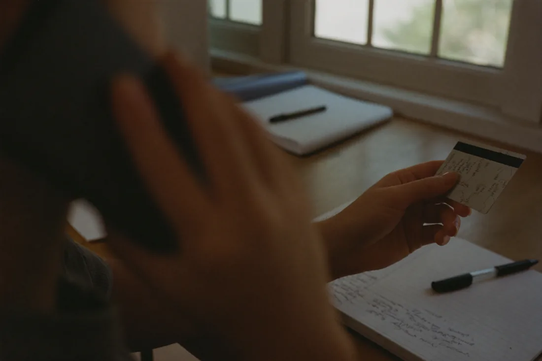 A first home buyer phoning their bank to reduce a credit card limit before applying for a home loan.