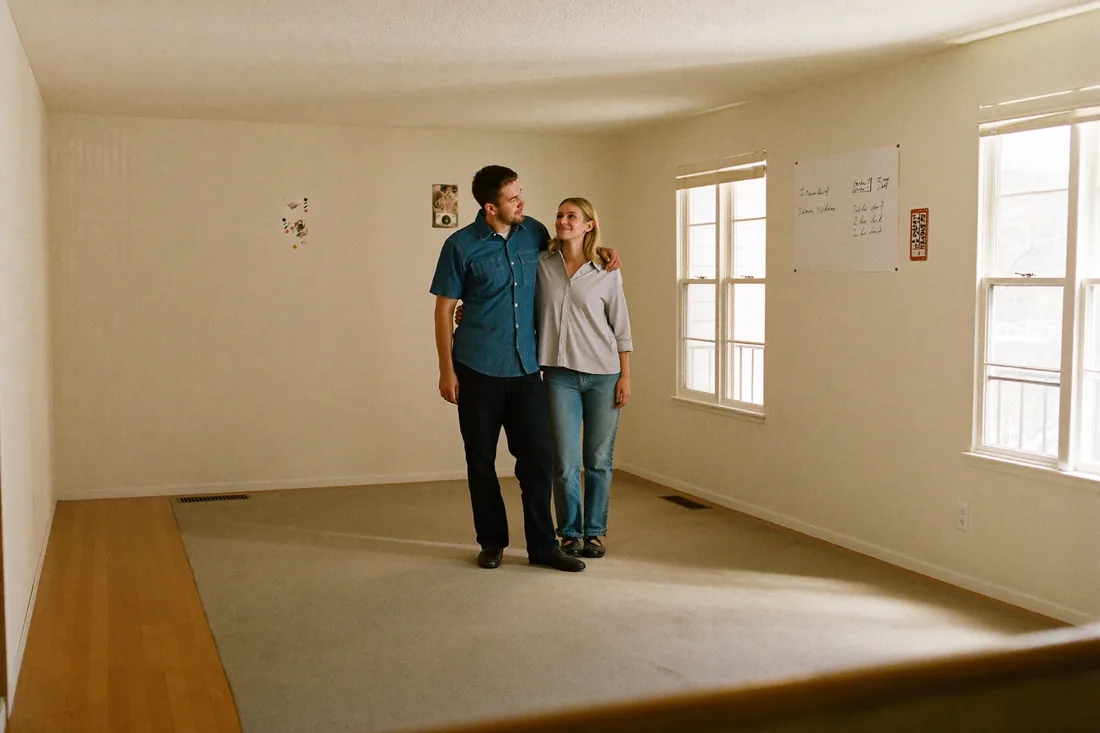 A young couple inspecting an empty older home at an open inspection in suburban Australia.