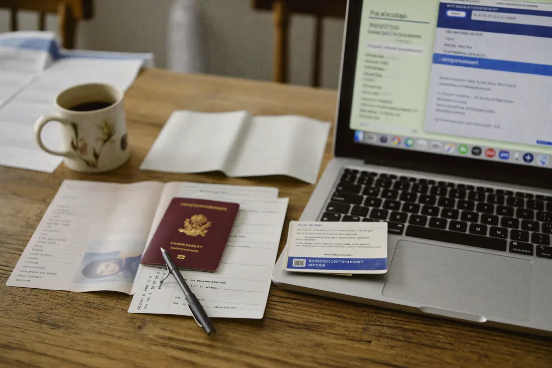 Home loan pre-approval documents laid out on a kitchen table: payslips, bank statements, photo ID and a laptop.