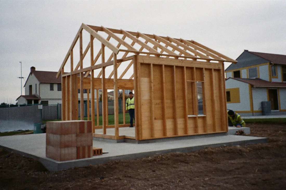An Australian house under construction at frame stage, showing the timber frame and roof trusses before lock-up.