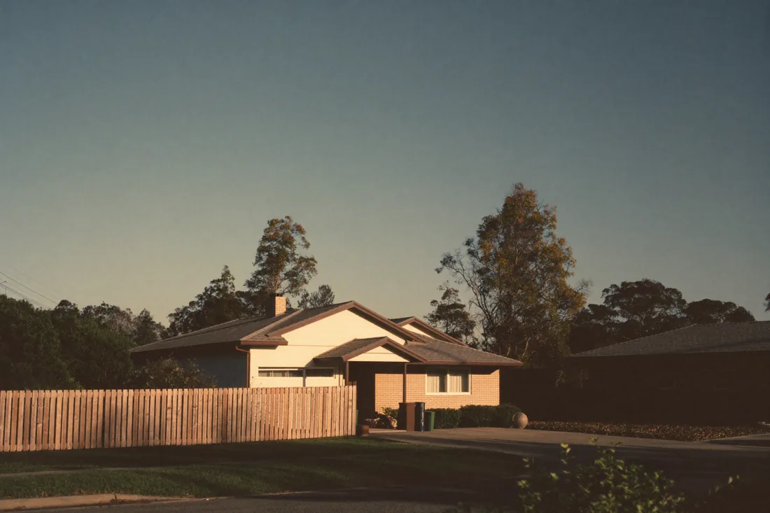 A modest established brick-and-tile house in a Perth suburb under a wide blue sky, typical of a first-home-buyer purchase under the scheme price caps.