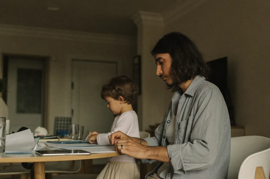 A single parent reviewing first home buyer scheme paperwork at home, illustrating the 2% deposit Family Home Guarantee for Australian families.