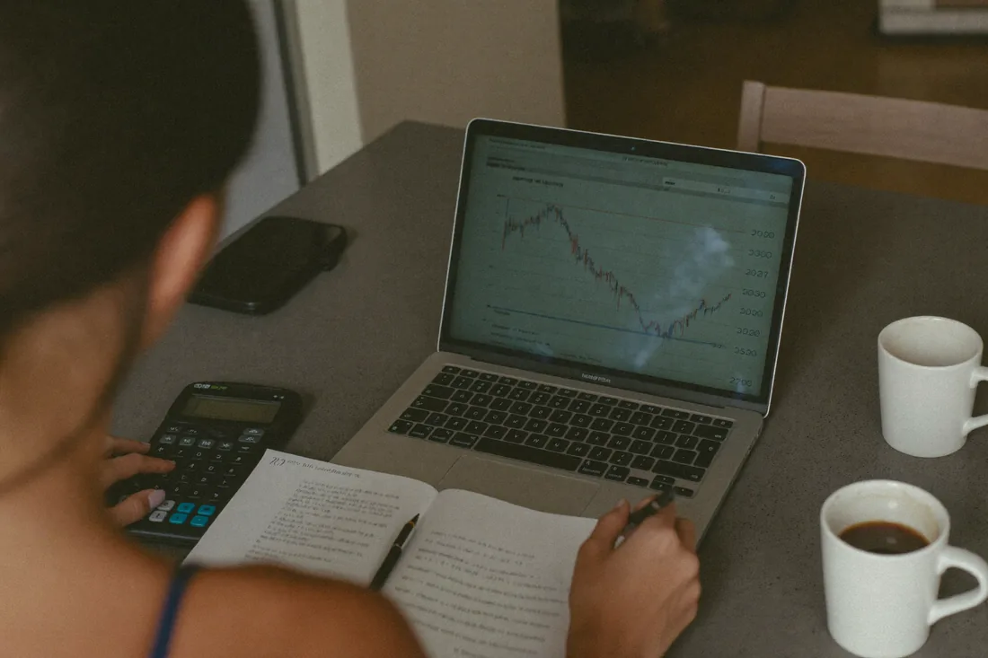 A young Western Australian couple working out Keystart home loan repayments on a laptop at their kitchen table.