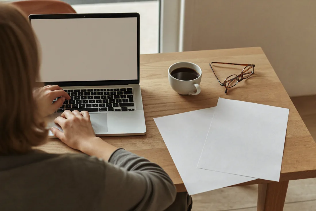 A person reviewing strata financial documents and a building's capital works fund statement at a kitchen table before buying an apartment.